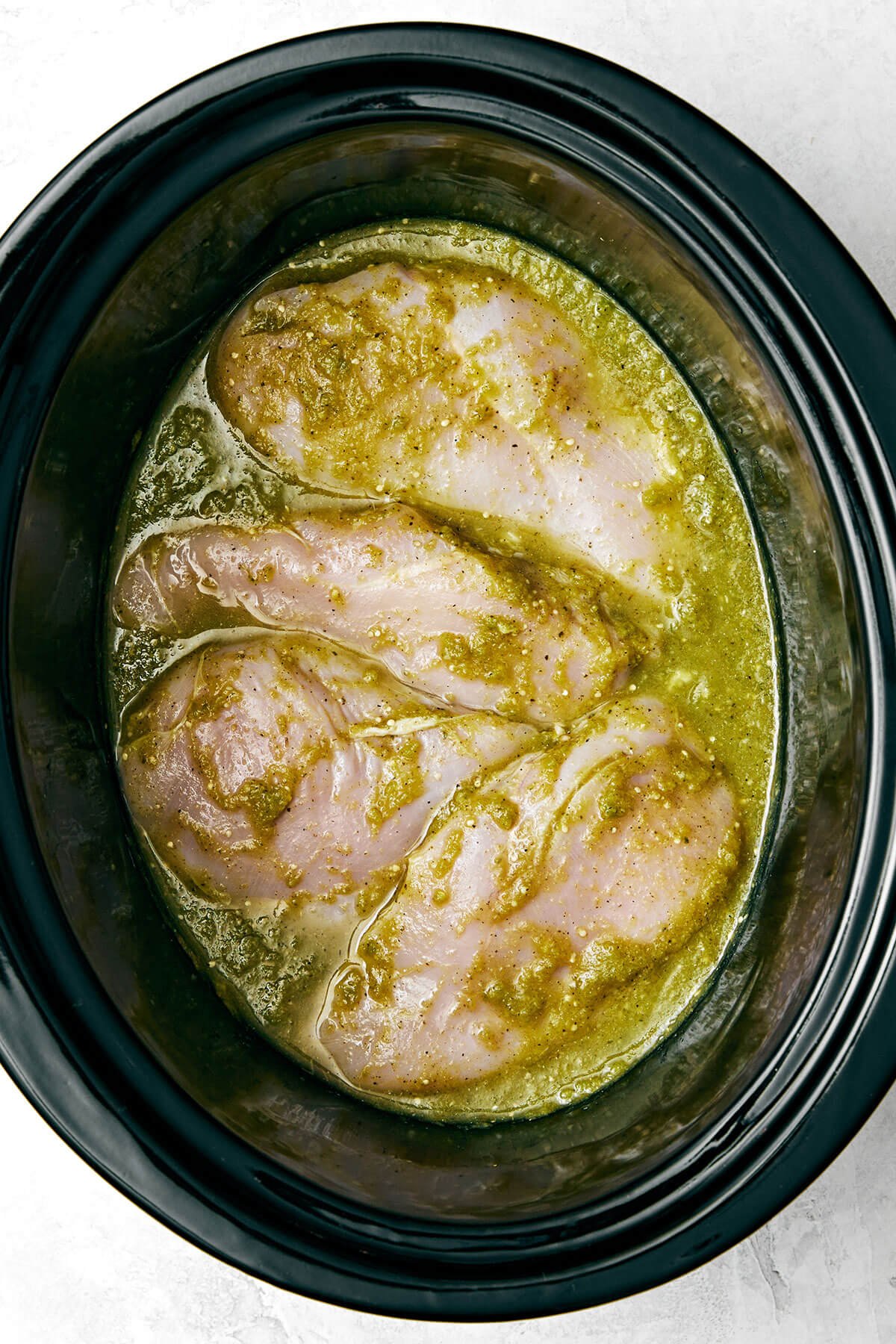 Chicken with salsa verde in a slow cooker.