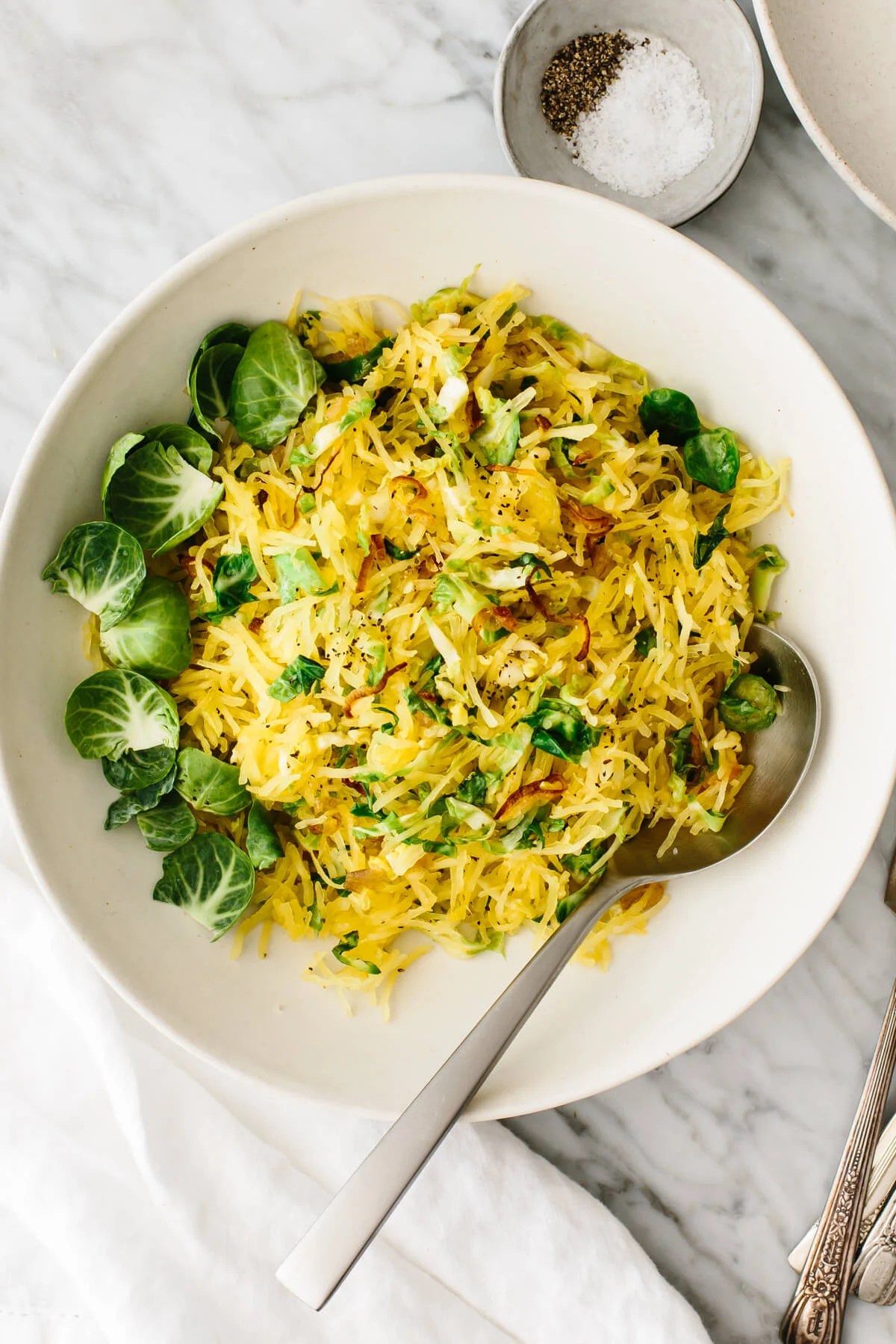 Spaghetti squash, Brussels sprouts, and crispy shallots side dish in a bowl.