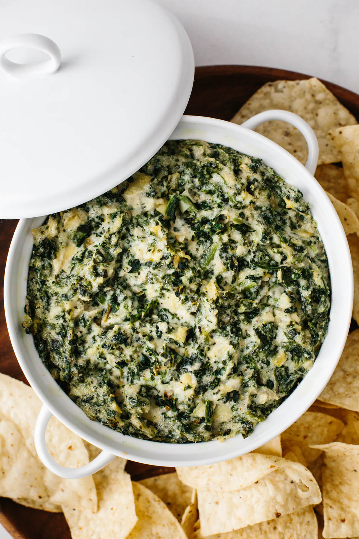 Spinach artichoke dip in a white casserole dish.