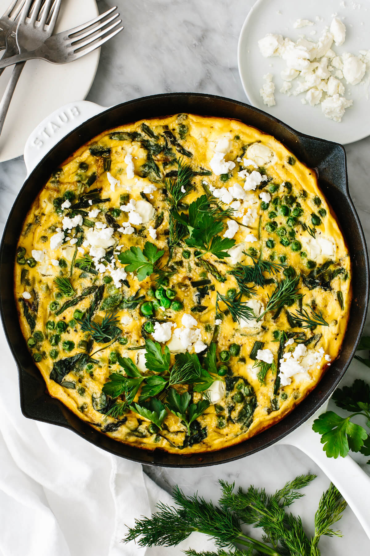 Spring vegetable frittata in a skillet on a table.
