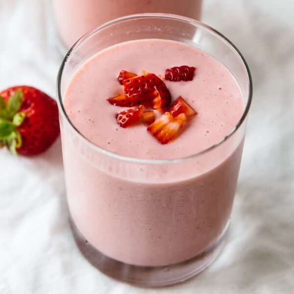 Strawberry banana smoothie topped with fresh strawberries.