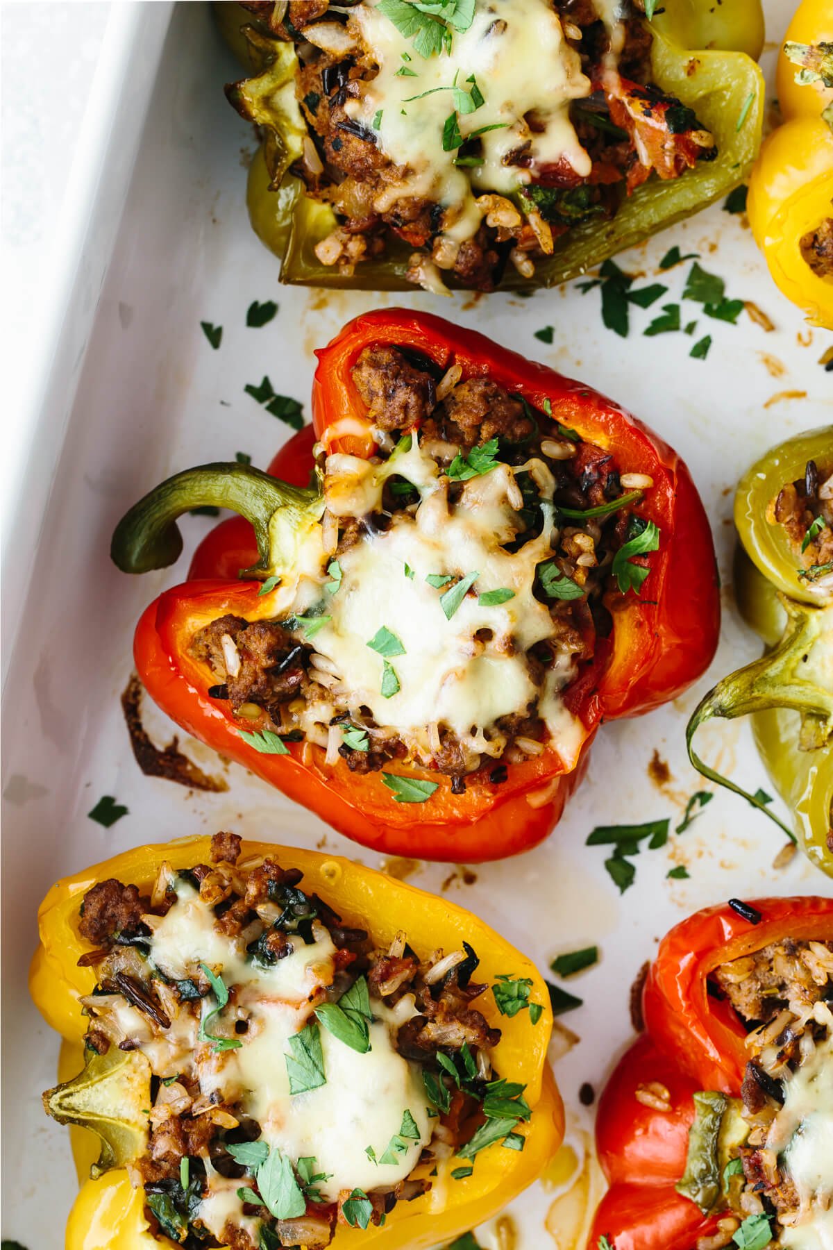 Close up photo of stuffed peppers in a baking pan.
