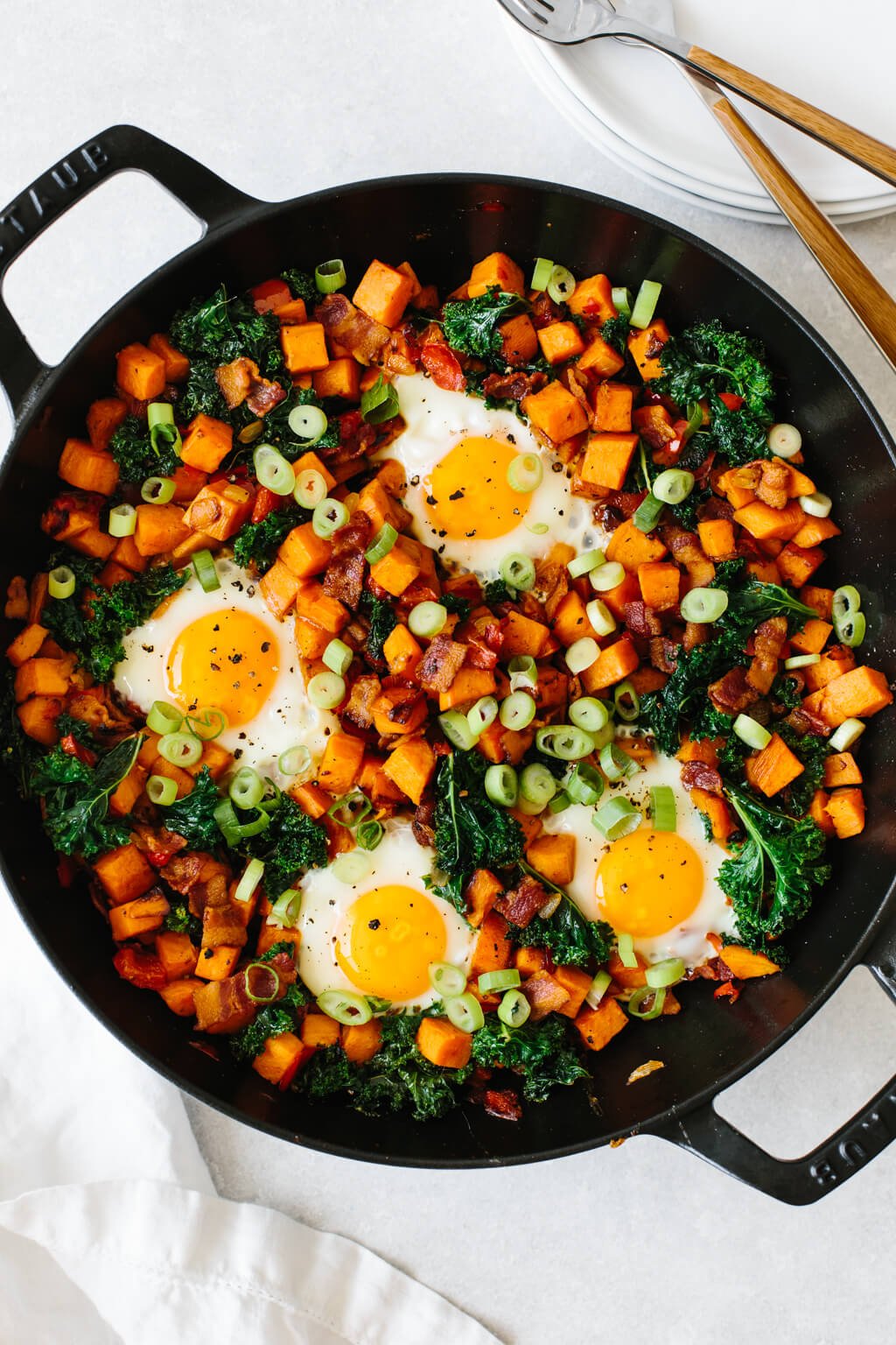 Cubed sweet potato and vegetables in a skillet with eggs.