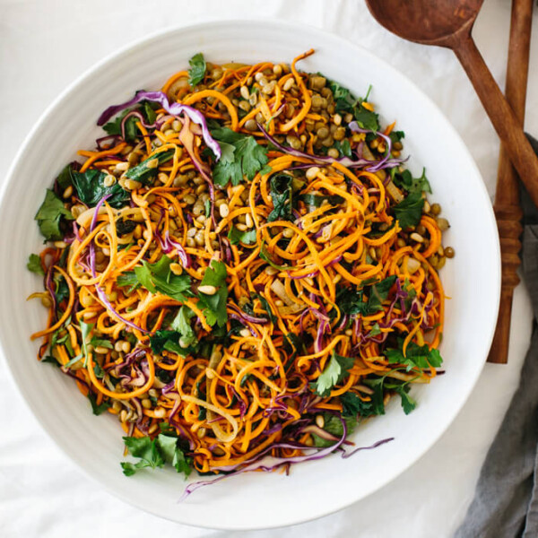 Sweet potato noodles salad is a combination of spiralized sweet potato noodles, cabbage, lentils, sautéed onions and Swiss chard. It's topped off with fresh herbs, toasted pine nuts and a zesty Dijon vinaigrette.