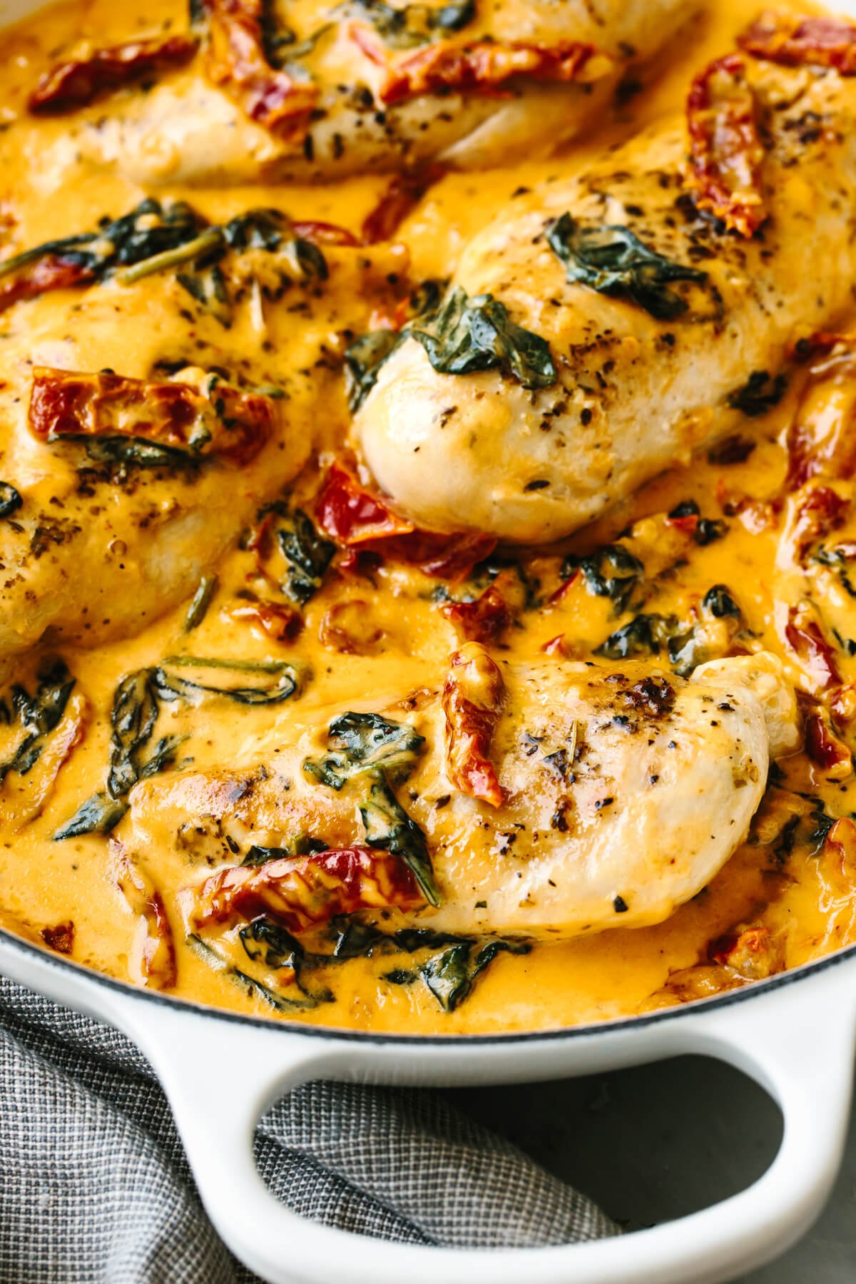 A white skillet filled with creamy tuscan chicken