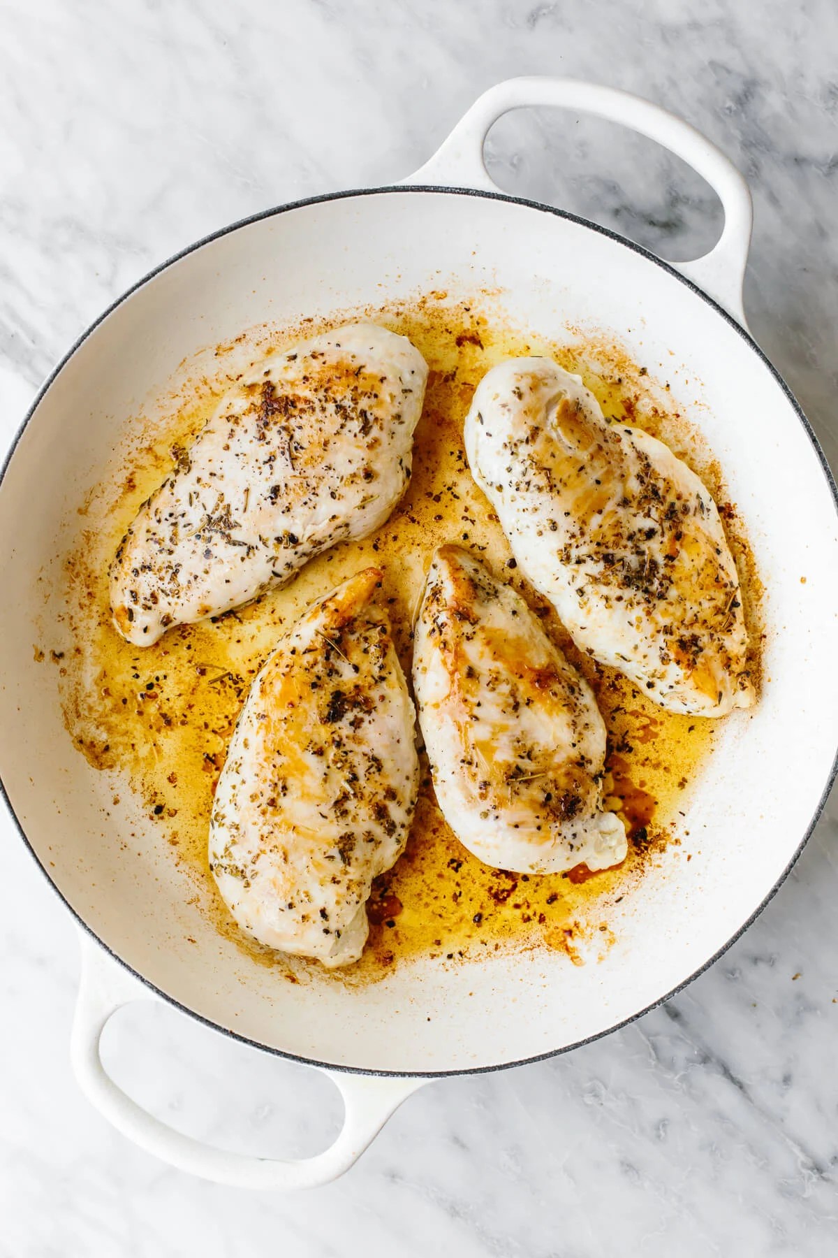 Cooking chicken breasts in a skillet for tuscan chicken