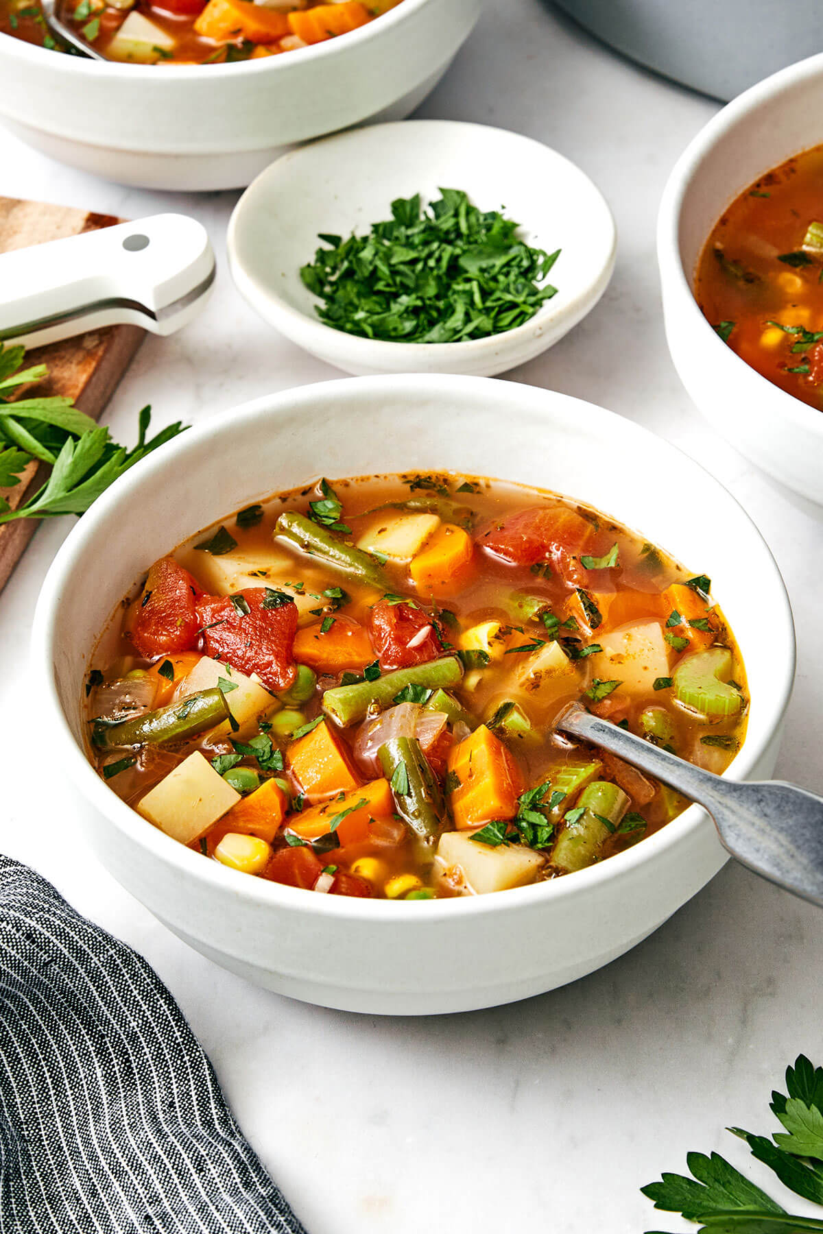 A bowl of vegetable soup with a spoon