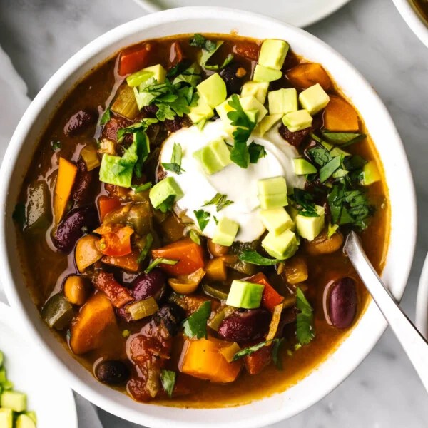 Vegetarian chili in a small bowl with diced avocado.
