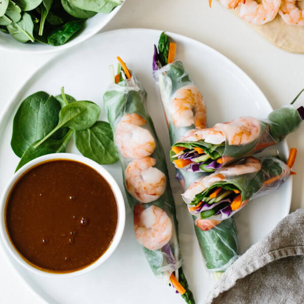 Vietnamese spring rolls on a plate next to dipping sauce.