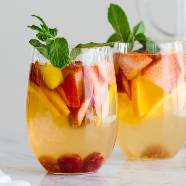 Two glasses of white wine sangria garnished with mint.