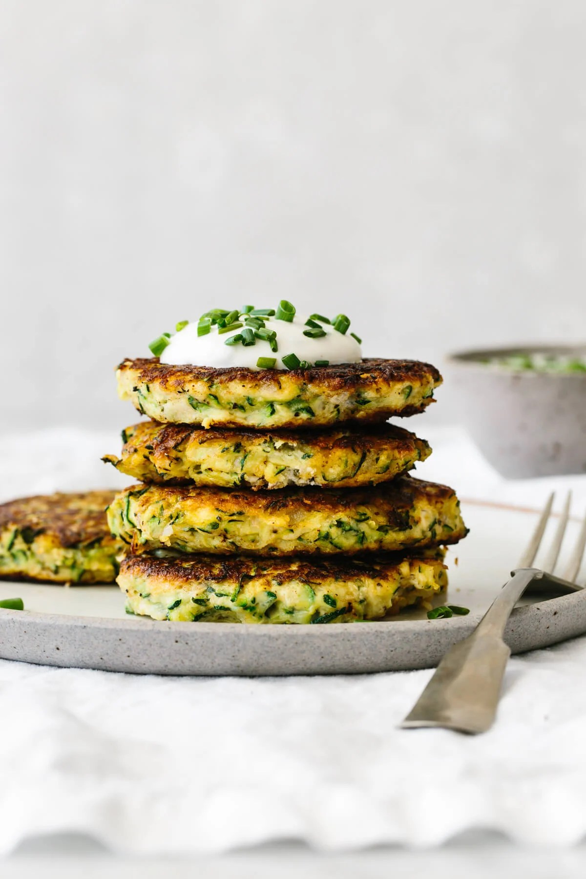 A stack of zucchini fritters on a plate.